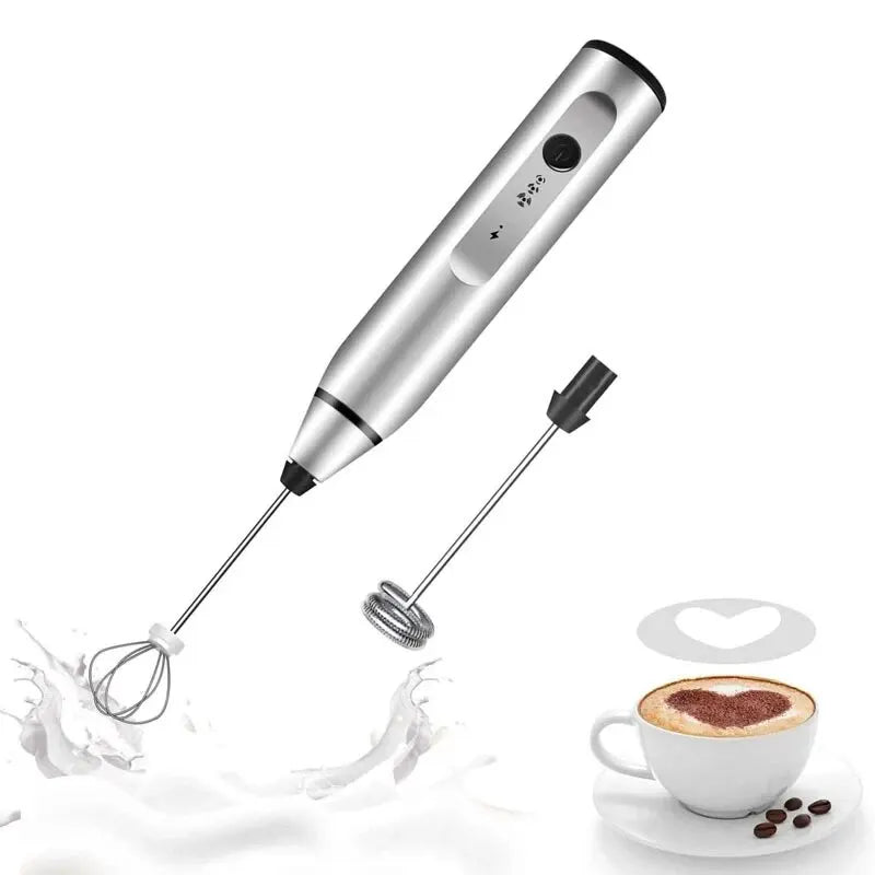 Coffee My Cup: Silver handheld milk frother with black accents next to a cup of coffee with a heart design.