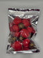 Coffee My Cup Sweet Treats Collection: Prosecco Berry Bliss – 4oz Bag: Red spherical objects with brown centers in a clear plastic bag on a gray background