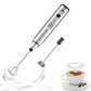 Coffee My Cup: Silver handheld milk frother with black accents next to a cup of coffee with a heart design.