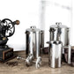 Coffee My Cup: Set of stainless steel coffee pots and a vintage grinder on a wooden surface.