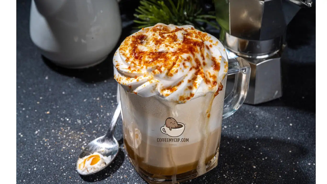 A creamy latte in a clear glass mug topped with whipped cream and a sprinkle of cinnamon.
