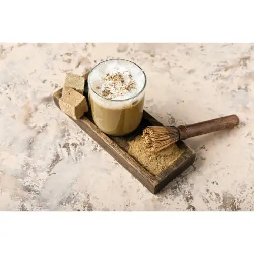Coffee My Cup Travel Indulgence Collection a glass of matcha latte with Coffee My Cup matcha powder and whisk on a wooden tray.